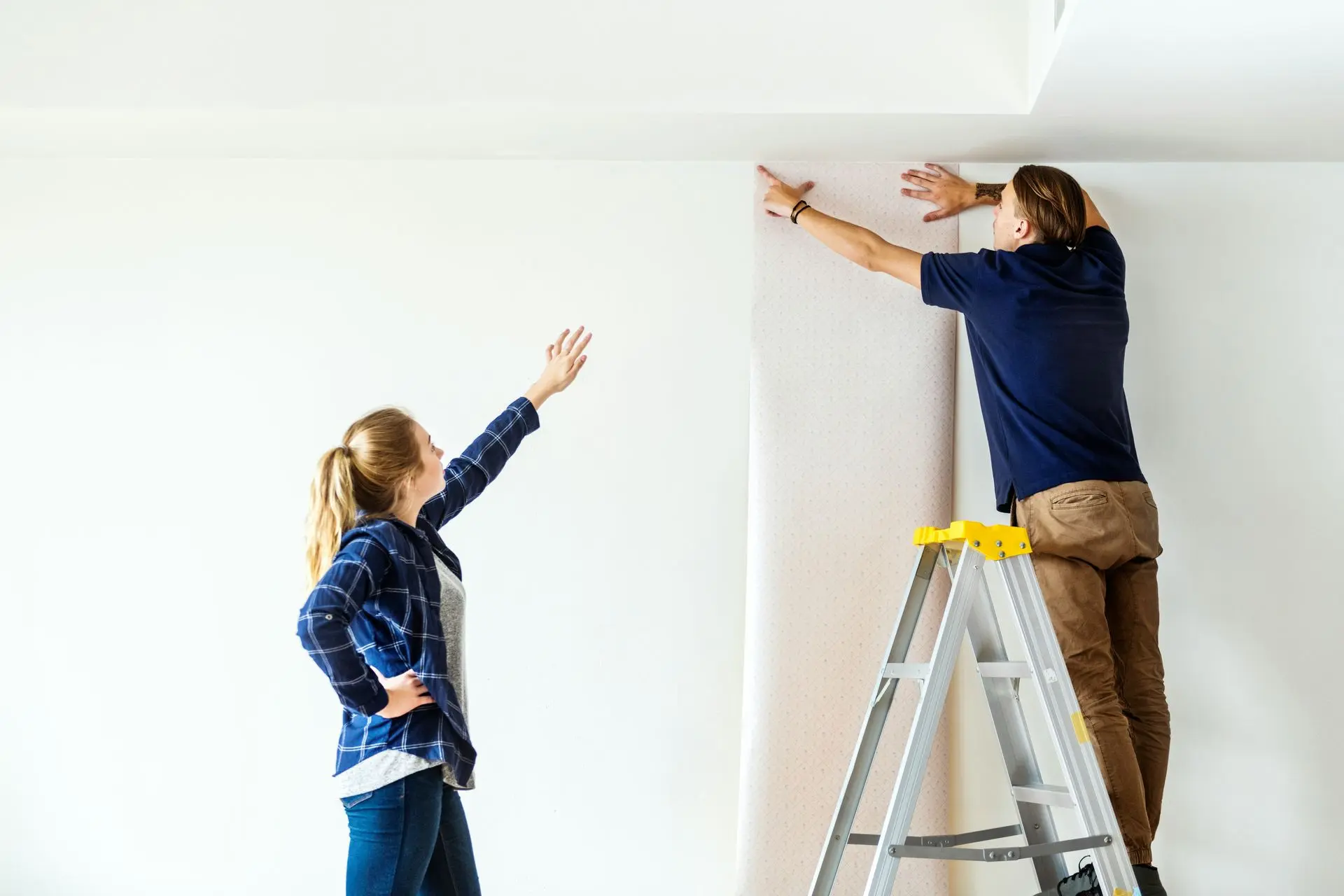 Immobilienaufbereitung – Aufwertung für optimale Verkaufspräsentation Zwei Personen beim Streichen und Herrichten eines Raumes