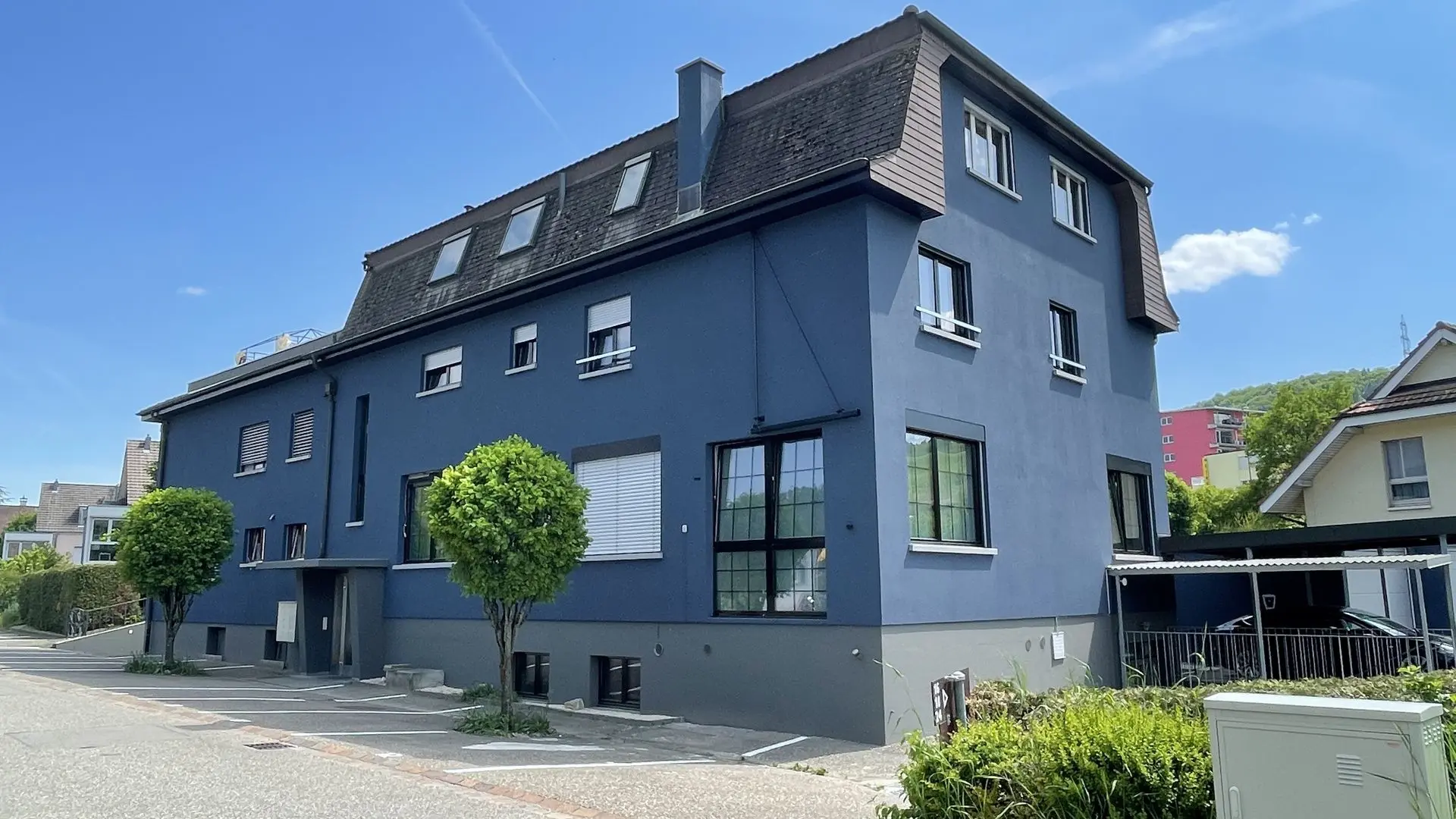 Verwaltung von Miet- und Eigentumsobjekten mit Organisation und Abrechnung "Mehrfamilienhaus mit gepflegtem Vorgarten – Symbol für professionelle Liegenschaftsverwaltung