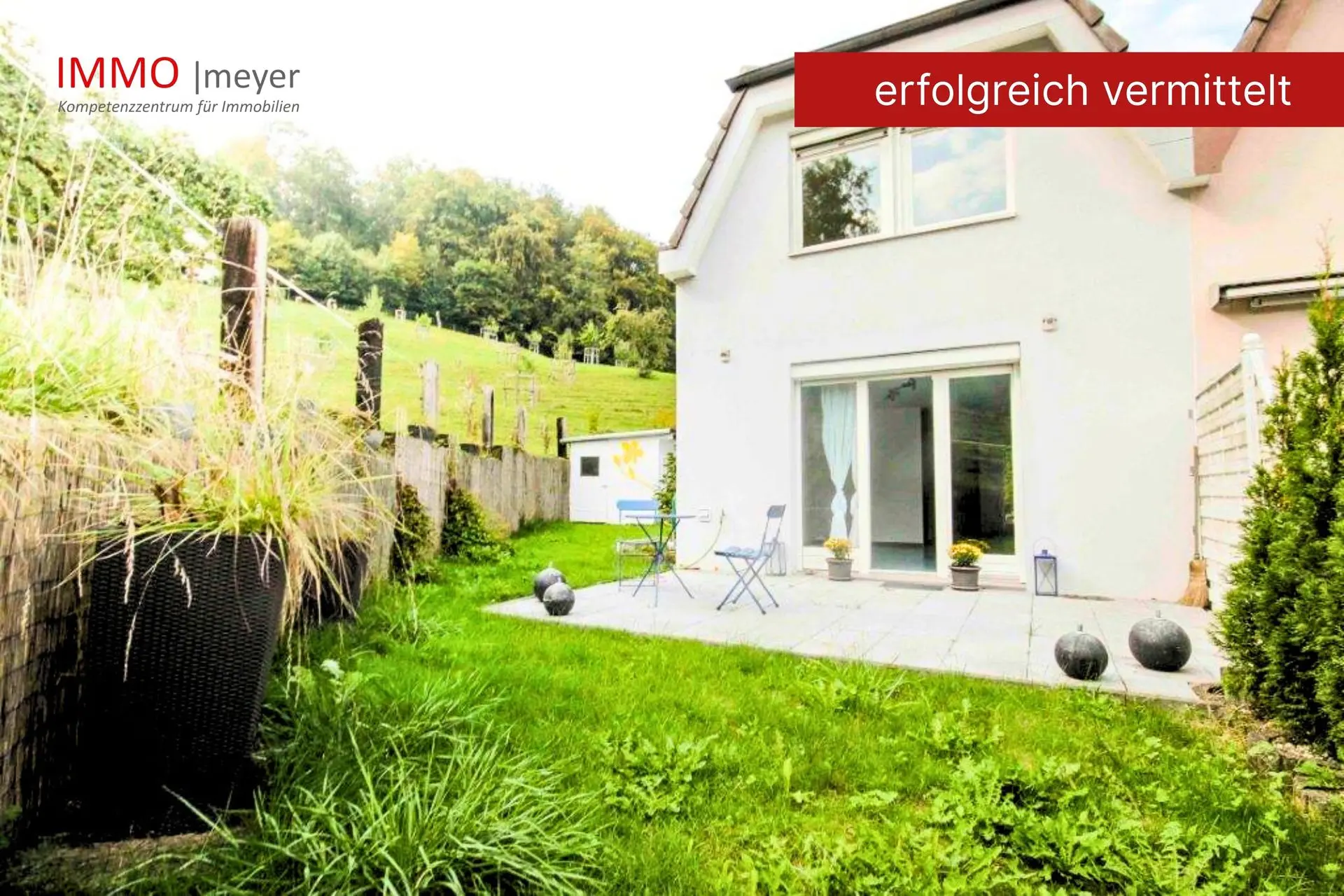 Haus mit Terrasse und Grünfläche am Hang