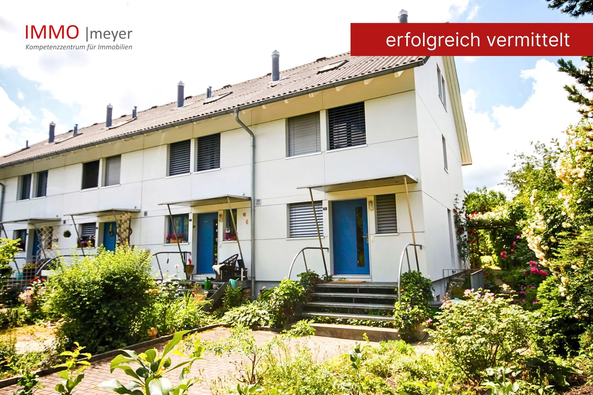 Modernes Reihenhaus mit blauem Eingang und Vorgarten