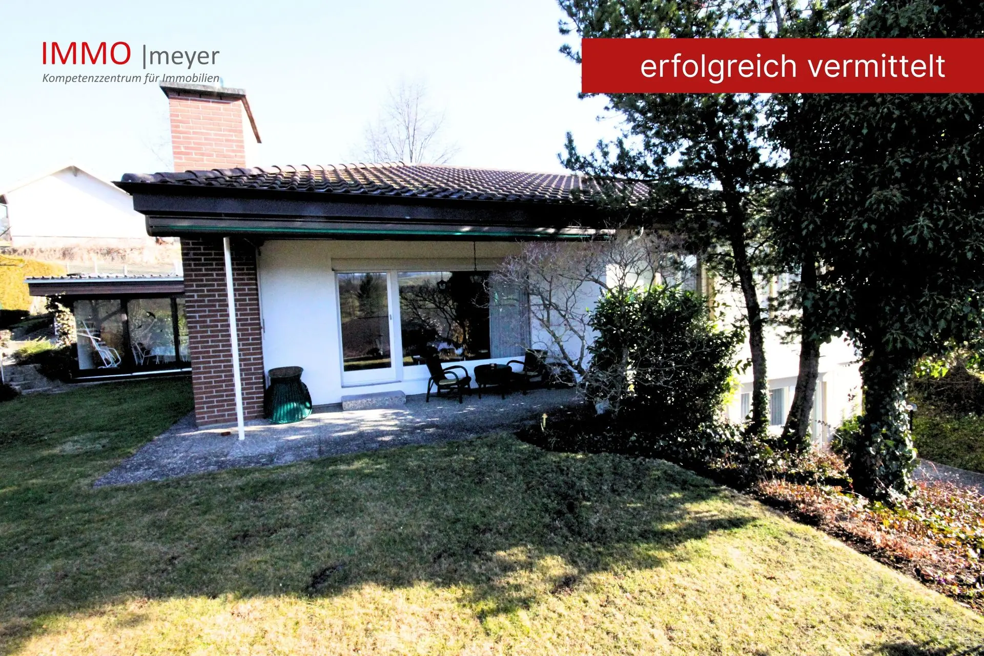 Flaches Einfamilienhaus mit Terrasse und Rasenfläche