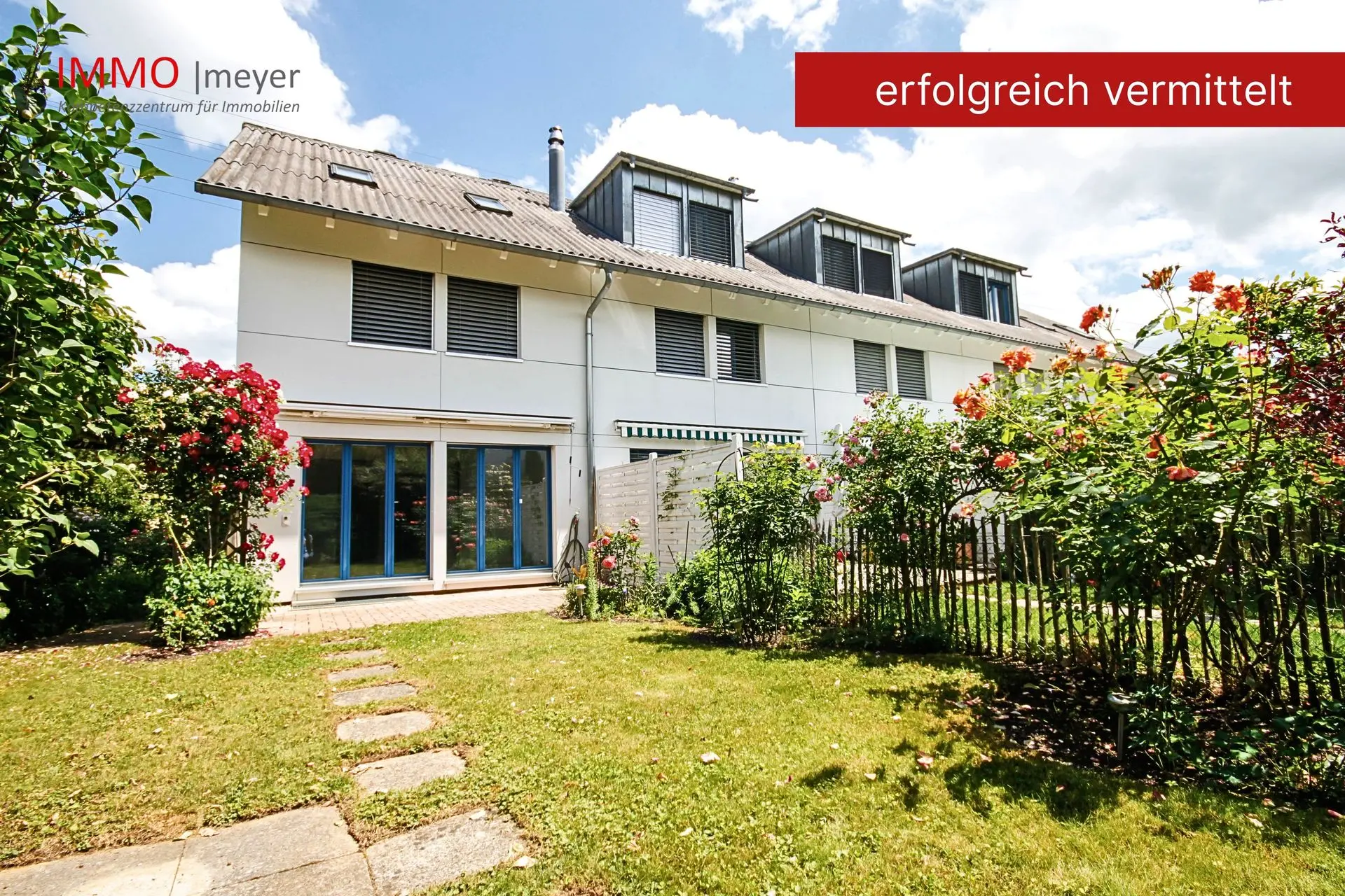 Haus mit Terrasse, Garten und blühenden Rosen
