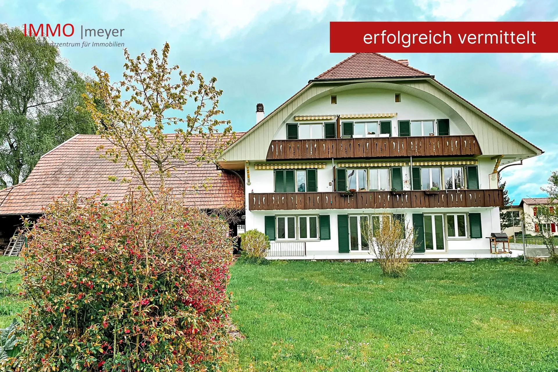 Traditionelles Bauernhaus mit Holzfassade und Wiese